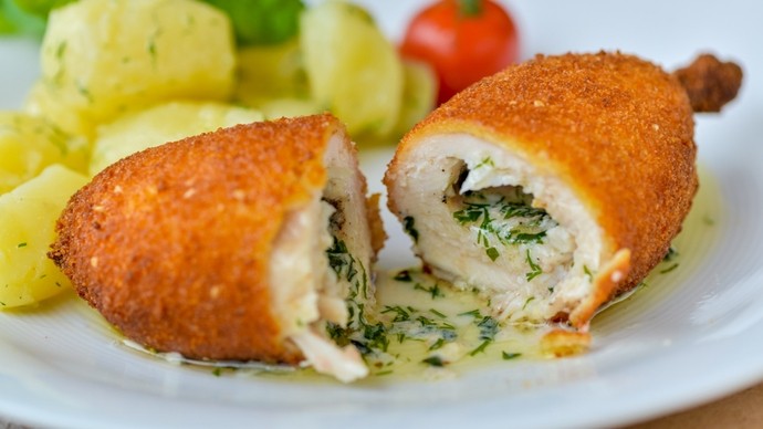 a halved breaded chicken kiev filled with a rich garlic sauce
