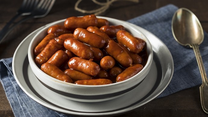 a pot of mini sausages covered in a rich brown sauce