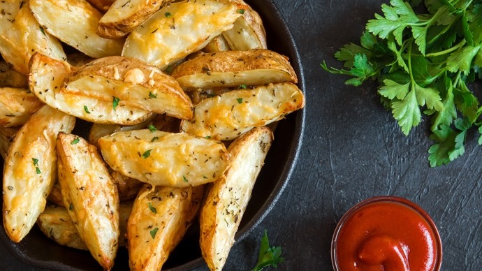 Dish full of potato wedges with melted cheese