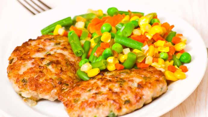 Two turkey burgers served with sweetcorn and beans
