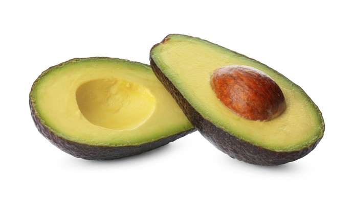 An avocado cut in half to show the stone