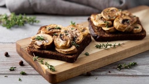 two slices of crisp toasted bread topped with sliced mushrooms
