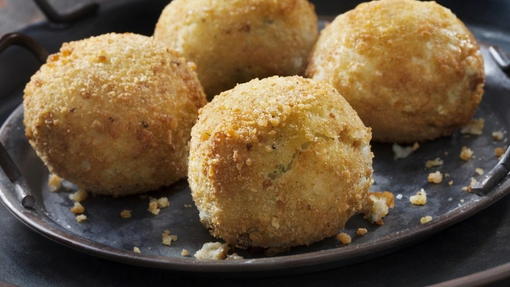 Round golden and crisp potato croquettes served on a plate