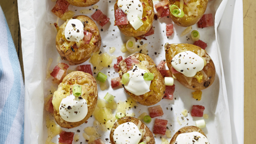 Baby potatoes topped with cheese, onions and bacon pieces