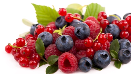 a pile of fresh summer berries - blueberries and raspberries