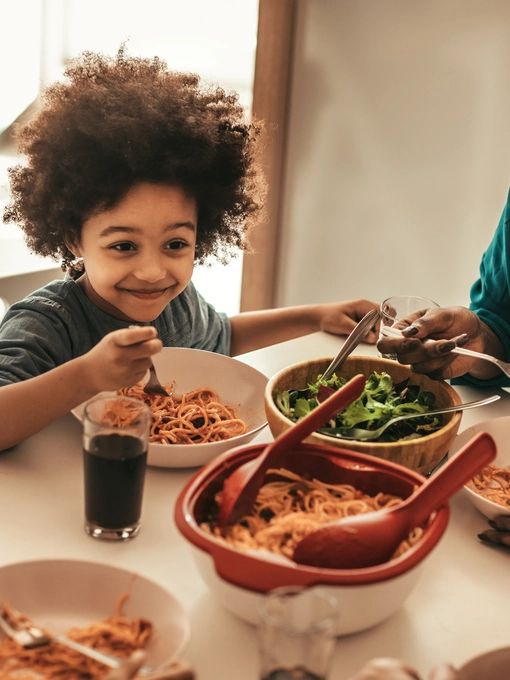 Family eating dinner together at the table enjoying their food