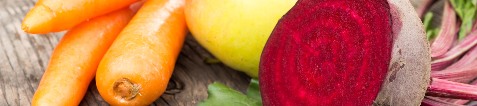 A few carrots, an apple and beetroot on a table