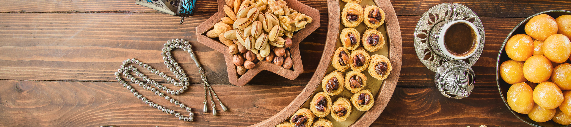 A wooden table with a spread of a variety of dishes.